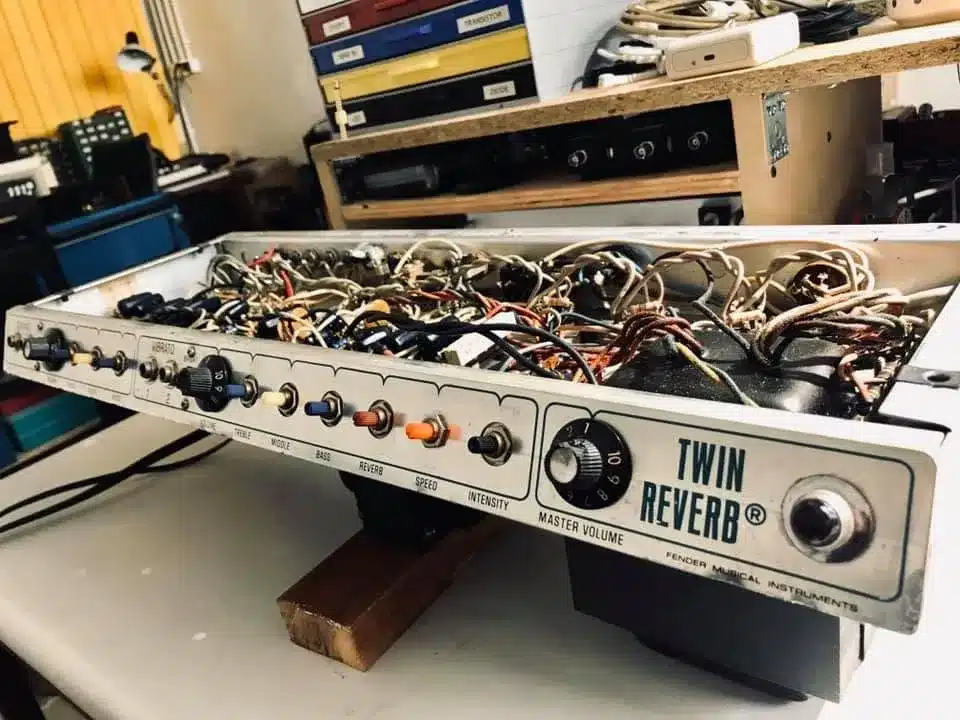 Intérieur d'un amplificateur Fender Twin Reverb démonté, montrant le câblage complexe et les composants.