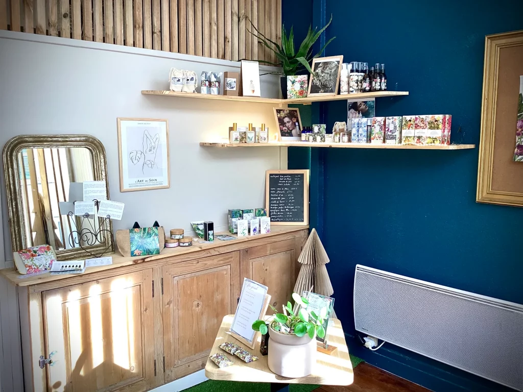 Mobilier en bois clair avec étagères exposant des cosmétiques et une plante verte sur un mur bleu.