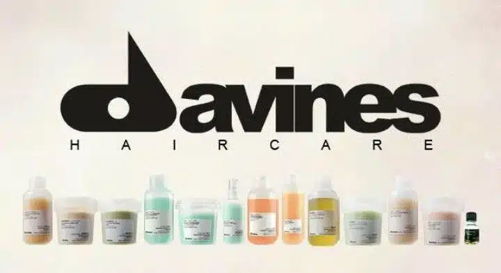 Produits de soins capillaires Davines, y compris des bouteilles et des pots, alignés devant le logo de la marque.