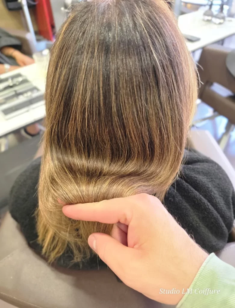 Un coiffeur examine la coupe de cheveux d'une cliente en studio