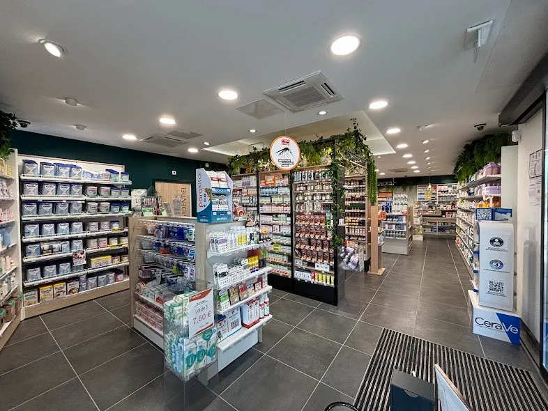 Intérieur d'une pharmacie spacieuse et moderne, bien achalandée en produits sur des étagères.