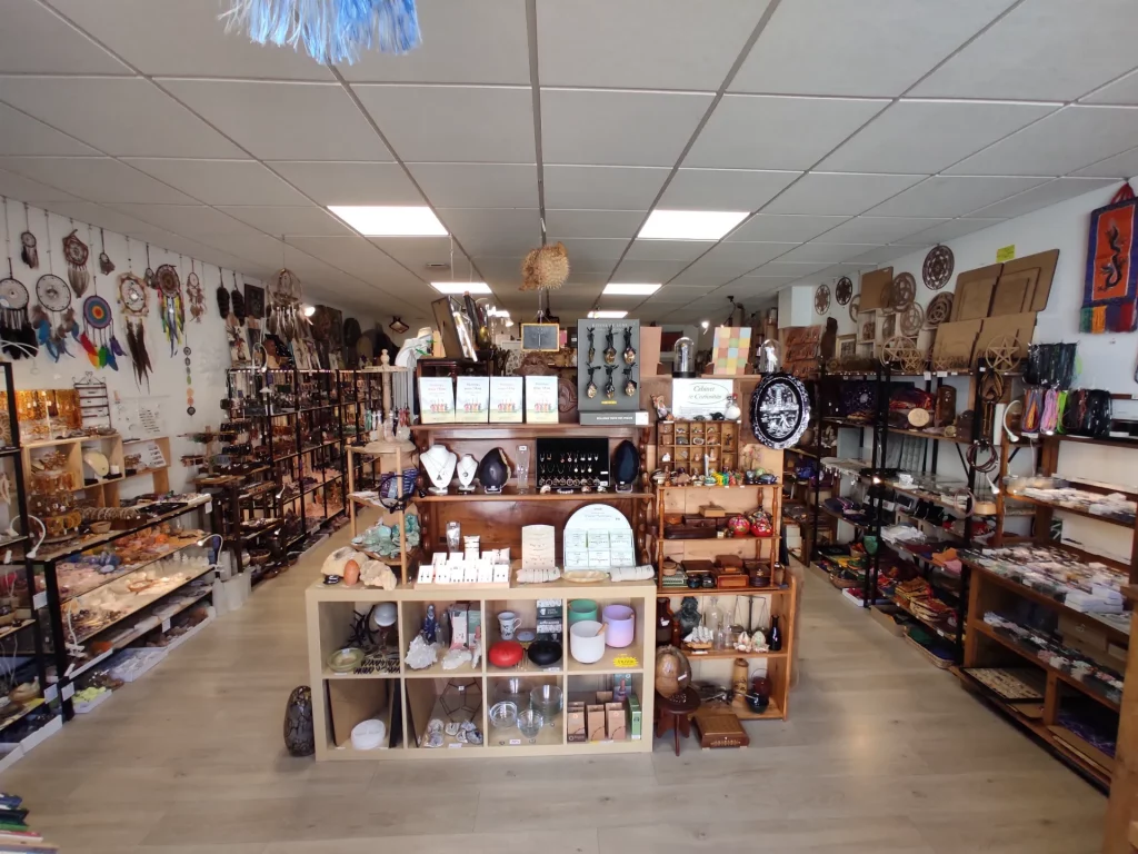 Vue intérieure d'un magasin proposant des objets ésotériques, des bijoux, des attrapes-rêves et des décorations murales.