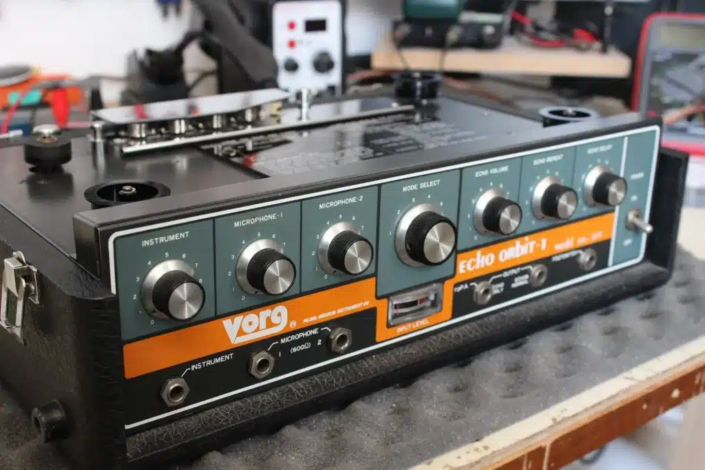 Vue rapprochée d'un unité d'écho à bande Vörg Echo Orbit-1 avec des potentiomètres pour l'instrument, les microphones et la sélection du mode.